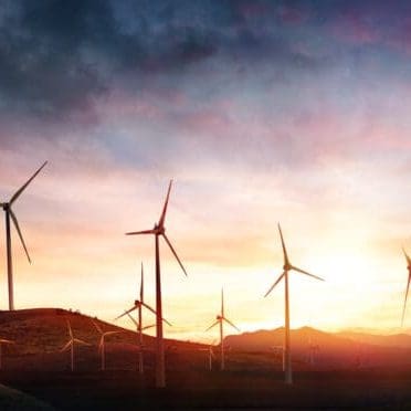 Wind Turbines In Rural Landscape At Sunset